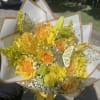 Yellow bouquet with roses, lilies, and daisies wrapped in white paper