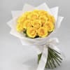 Bouquet of yellow roses wrapped in white paper with a ribbon