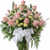 Pink roses and mixed flowers in a glass vase with a white bow