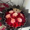 Bouquet of red and blush roses with a jeweled crown in black wrap