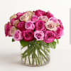 A delicate flower arrangement in a clear glass vase features an elegant