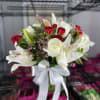 Bouquet of white lilies and red roses with a white ribbon