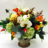 Mixed bouquet with orchids, roses, hydrangeas, and orange calla lilies in a metal vase