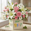 Soft pink roses and creamy white lilies form the heart of this