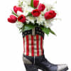 Red and white tulips burst from a novelty cowboy boot vase painted