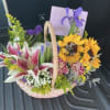 An uplifting garden-style basket filled with radiant sunflowers, fragrant stargazer lilies, vibrant