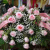 Large pink rose arrangement with baby’s breath and pink ribbons