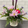 Mixed bouquet in a floral ceramic vase with pink and purple blooms