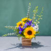 This Blue Sky Floral will sure brighten anyone&rsquo;s day. Sunflowers and iris