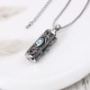 Silver pendant necklace with blue stones on a white surface