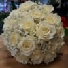 Cream-white roses gathered into a rounded, hand-held bouquet create an instantly romantic