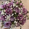 Lavender roses clustered into a neat, round wedding bouquet create a soft