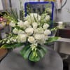 A refined cluster of white roses and white hydrangeas framed by arching