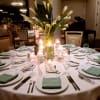 Tall white calla lilies rise like sculpted candles from a clear cylindrical