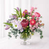 Blushing Meadow features a romantic mix of pink ranunculus, lavender tulips, delicate