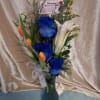 Vivid blue roses set the tone in this striking flower arrangement, their