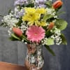 A cheerful arrangement featuring tulips, gerbera daisies mix with different flowers in