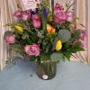 A bright, romantic bouquet built around one dozen purple-accented roses makes a