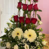 Deep red roses rise above a cloud of white blooms in this