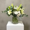 Pale yellow lilies unfurl above a cloud of white roses and clustered