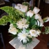 White tulips and spider mums arranged with green blooms in a vase.
