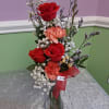 Three romantic red roses take center stage in this petite flower arrangement