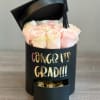 Pink roses in a black graduation box with a tassel