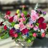 Lush layers of pink and red roses, bright pink tulips, and mini