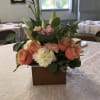 A low, romantic centerpiece in a rectangular wooden box blends peach roses