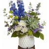Tall blue delphinium spikes rise above a soft cloud of white daisies