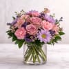 A charming blend of soft blush roses, delicate pink carnations, lavender daisies