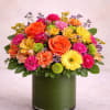 A vibrant and joyful arrangement bursting with warm oranges, bright yellows, lively