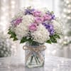A soft and elegant arrangement featuring lavender roses, white hydrangeas, delicate lavender