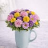 A joyful mix of soft pink carnations, lavender and yellow daisy poms