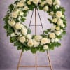 A timeless standing wreath designed with fresh white roses, carnations, and lush