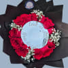 A bold ring of vivid red roses framed by delicate white baby's