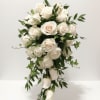 A romantic, flowing arrangement of ivory roses accented with lush greenery, designed