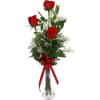 Three red roses in a clear glass vase with a red ribbon
