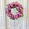 A grand and deeply comforting funeral standing wreath, beautifully crafted with a