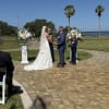 Soft white roses and billowing hydrangeas rise from elegant white pedestal stands