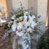 White phalaenopsis orchids cascade gracefully from a tall, airy arrangement-perfect as ceremony
