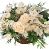 White roses and small white flowers in a wicker basket