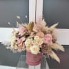 Pink and white rose arrangement in a pink hat box with dried pampas grass