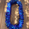 Blue hydrangea flower lei laid on a wooden surface