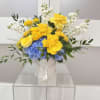 Yellow roses and blue hydrangeas in a white hatbox with white flowers.