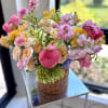 A joyful garden-style arrangement bursting with romantic pink blooms such as peonies