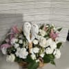 Basket arrangement of white roses, carnations, and pink lilies with angel wings