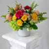 A cheerful garden-inspired arrangement bursting with vibrant seasonal blooms in shades of