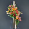 Tropical floral standing spray with lilies and orchids on bamboo