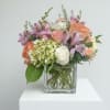 Soft pink and peach-toned blooms mingle with lavender snapdragon spikes in a